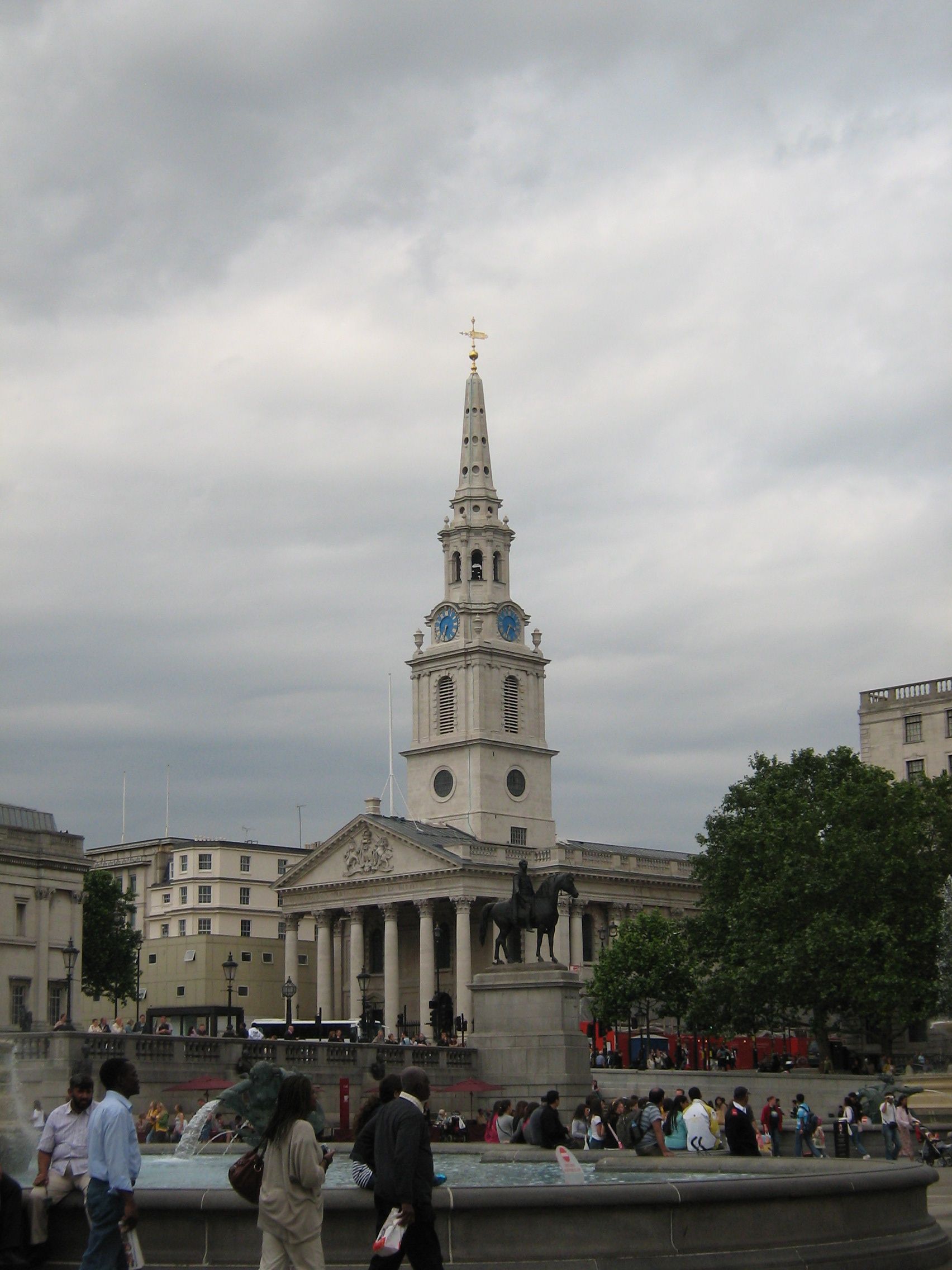 white church with spire and pillared front, seen across bowl of fountain